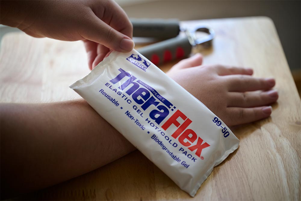 a child's wrist using TheraFlex hot and cold therapy packs