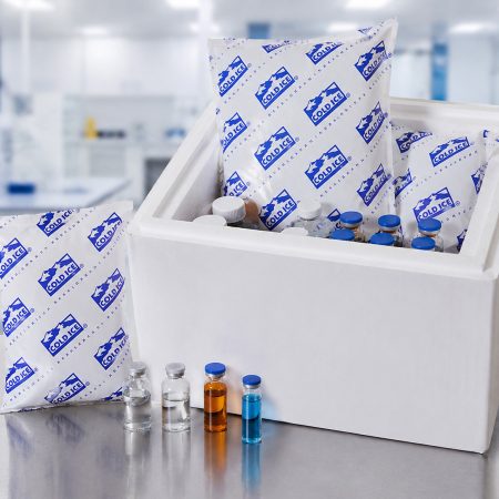 Cold Ice gel refrigerant packs inside an open insulated foam shipping container with pharmaceutical vials.